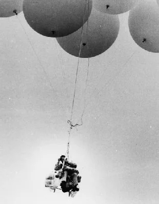 Lawnchair Larry in his lawn chair, held up by weather balloons